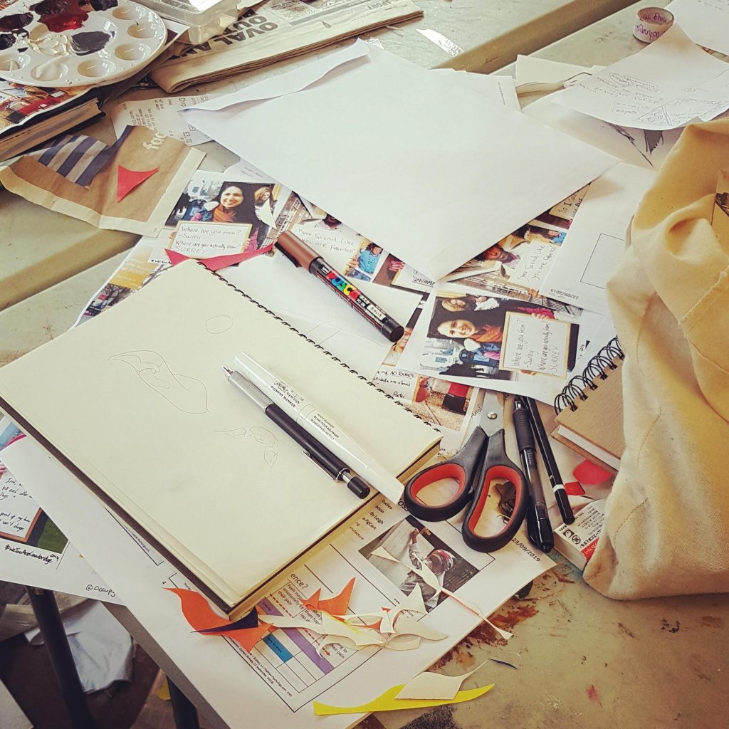 Messy desk as students cut up pages to create posters