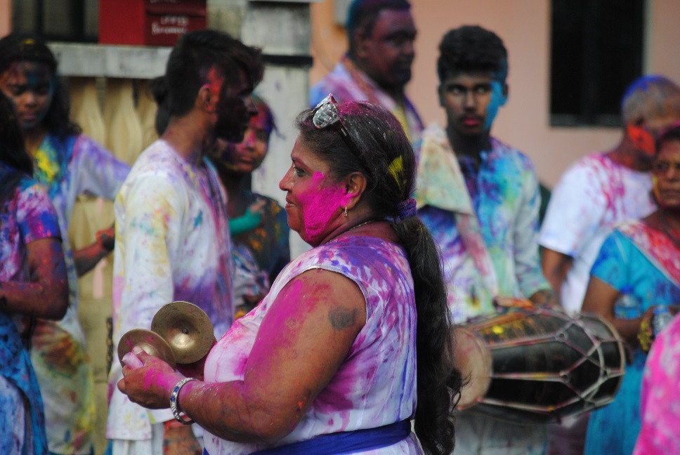 People dressed in white splashed with bright coloured powders and paints for the Hindu festival, Holi or Phagwah