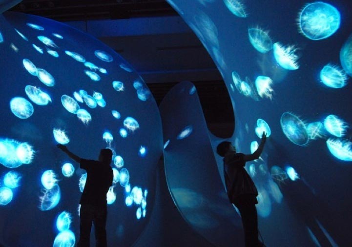 People interact with light projections at Takahiro Matsuo's "Into the Light Sea"
