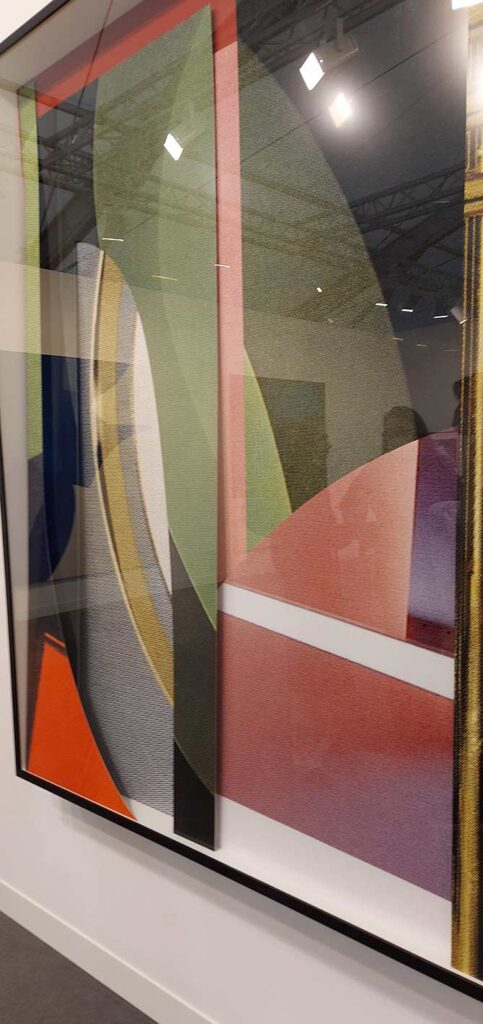 side view of irregularly shaped cut-outs in various muted shades within a box frame that keeps the taller shapes upright. Altogether they look like a geometric abstract piece when viewed head on.