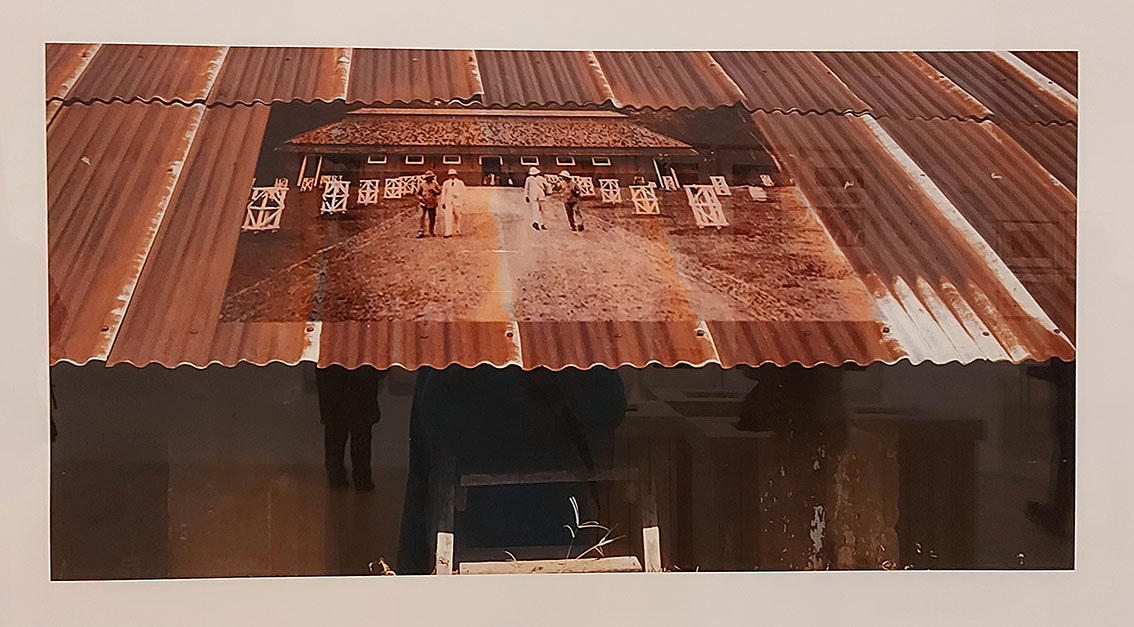 rusty galvanize roof with an old image of a similar building from centuries ago with plantation owners and maybe foremen walking along a path