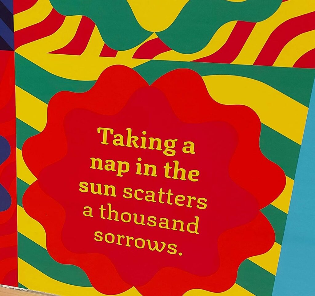 colourful patterns with the text: Taking a nap in the sun scatters a thousand sorrows